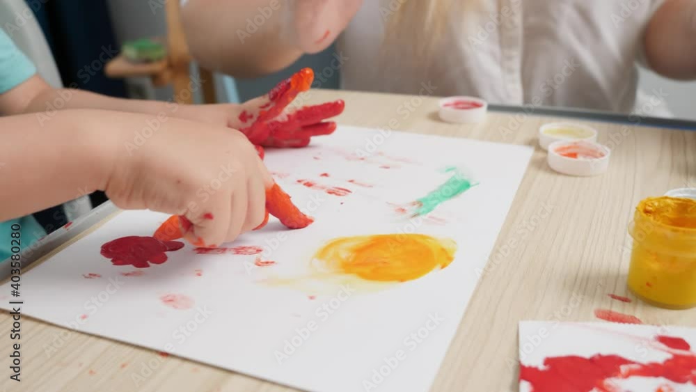 Closeup video of mother and little son drawing picture with fingers covered in colorful paint. Family having fun. COncept of art, creativity and child learning Closeup video of mother and little son drawing picture with fingers covered in colorful paint. Family having fun. COncept of art, creativity and child learning