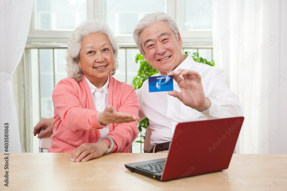 An old senior couple holding credit card An old senior couple holding credit card