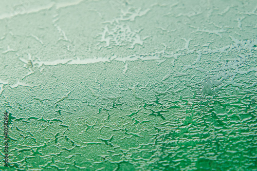 Abstract image. Green texture of the ice in the glass