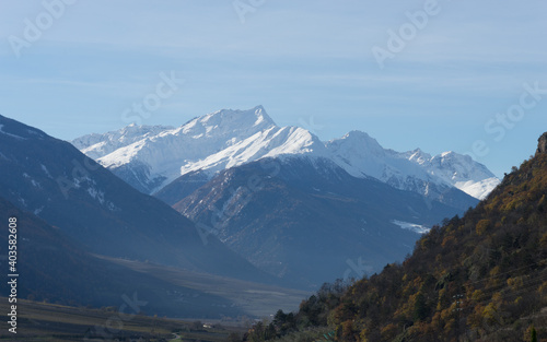 Picturesque mountain landscape in Naturns in South Tyrol in autumn, snow-covered mountains, blue sky with clouds, no people