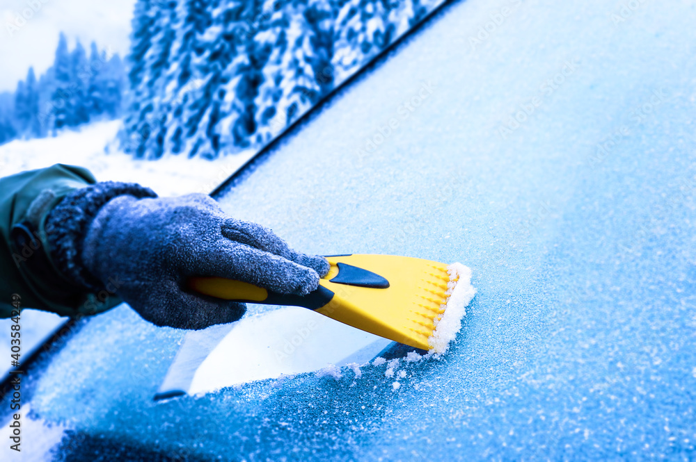 Clearing snow from windshield, Scraping ice. Winter season car window cleaning. Holiday in ski resort. - obrazy, fototapety, plakaty 