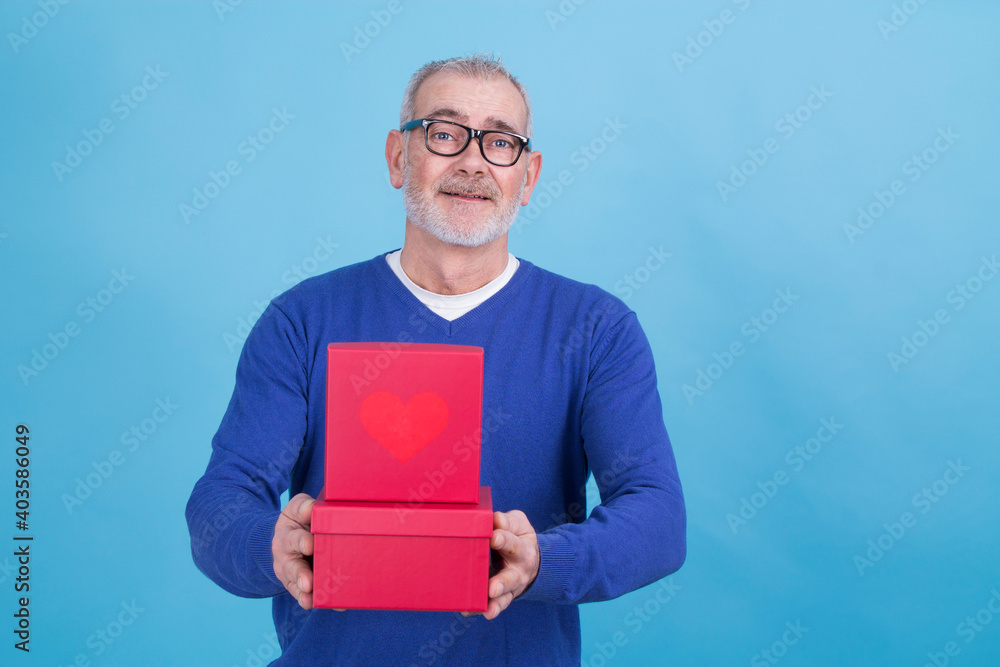 Happy Holidays, my congregations! Portrait of an attractive casual man giving present box isolated over blue background Happy Holidays, my congregations! Portrait of an attractive casual man giving present box isolated over blue background