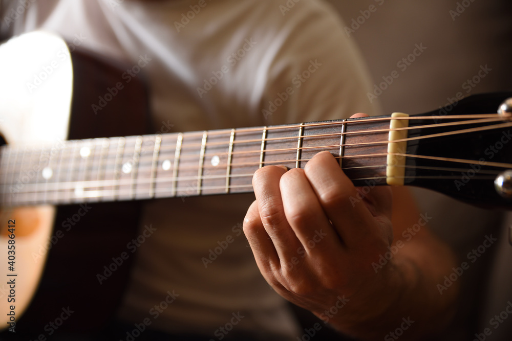Fototapeta premium Acoustic guitar fingerboard detail and hands playing