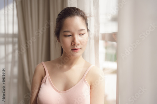 Portrait of young asian beauty woman in pink shirt in white room.