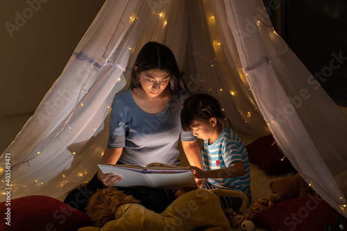 Happy family asian mother and daughter reading a book