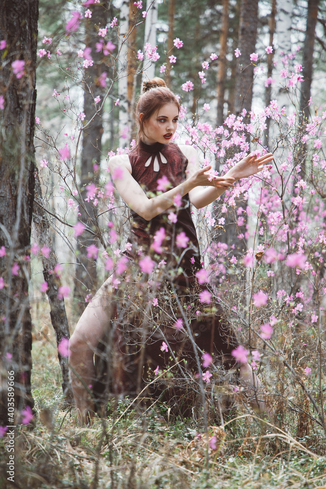 Japanese-style girl in a flowering forest among pink flowers in spring Japanese-style girl in a flowering forest among pink flowers in spring