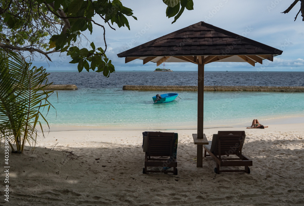 Tropical beach with two chairs and an umbrella Ellaidhoo Maldives