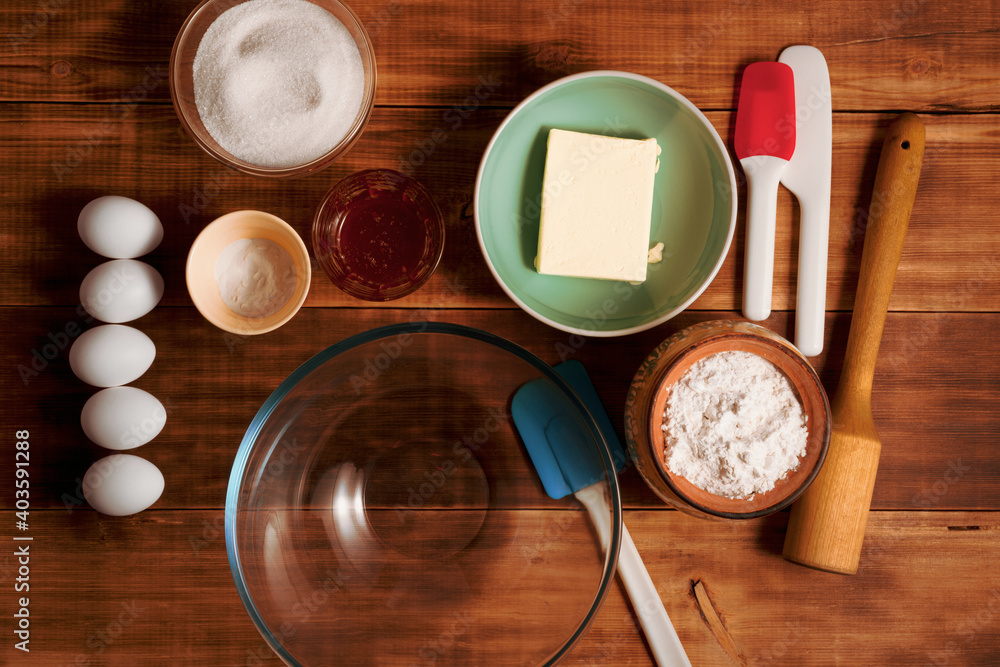 Bakery ingredients and kitchen utensils on wooden rural kitchen table for baking thematic background. Bakery ingredients and kitchen utensils on wooden rural kitchen table for baking thematic background.