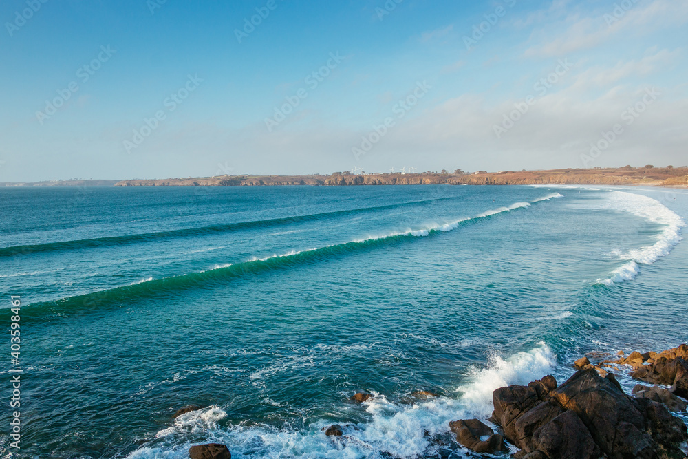 Waves are coming in the bay and crashing on the beach of Les Blancs Sablons, Finistère, Bretagne, France