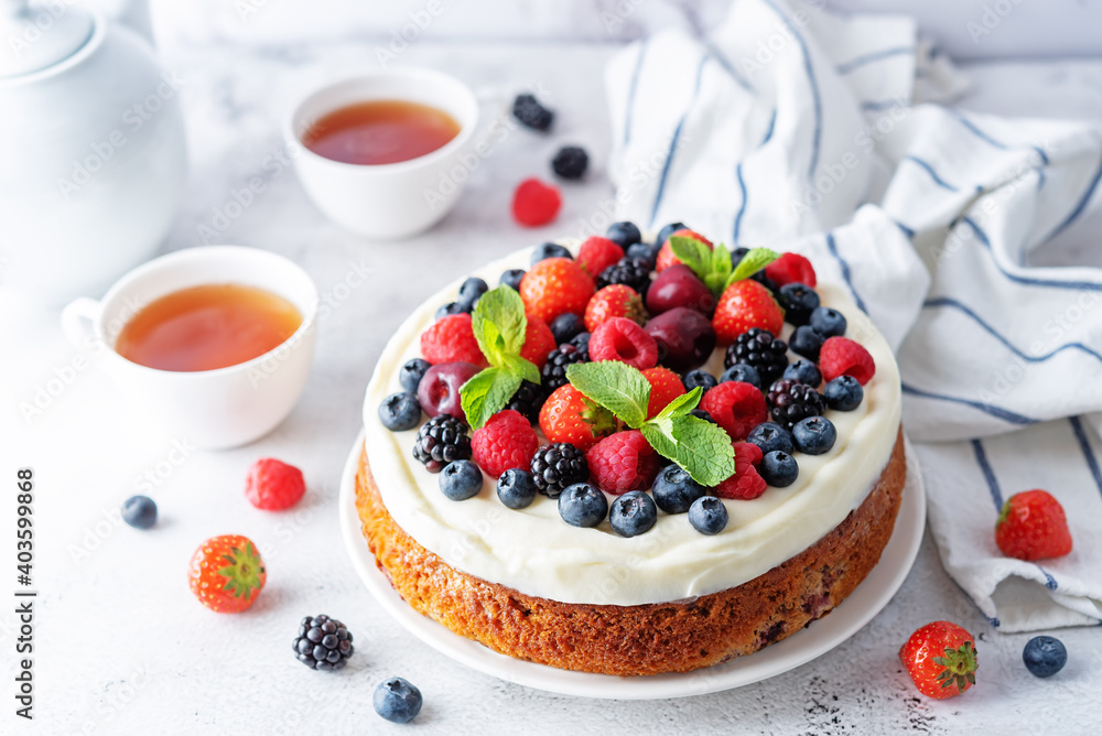 Cake with cream cheese frosting, mint leaves and strawberries, blueberries; blackberries and raspberries Cake with cream cheese frosting, mint leaves and strawberries, blueberries; blackberries and raspberries