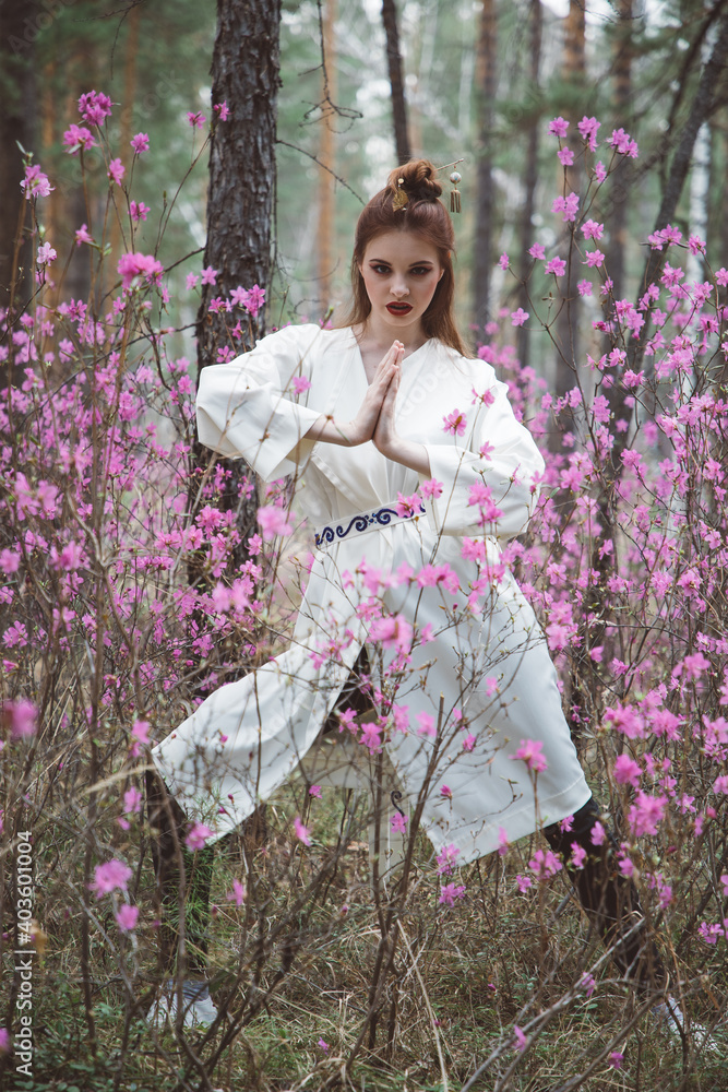 Japanese-style girl in a flowering forest among pink flowers in spring Japanese-style girl in a flowering forest among pink flowers in spring