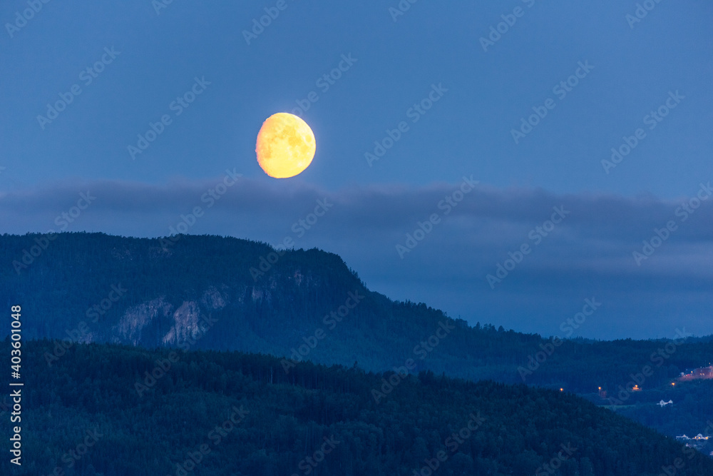 The Moon over green mountains in Norway