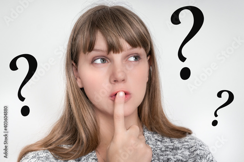 Woman with finger on her lips and question marks