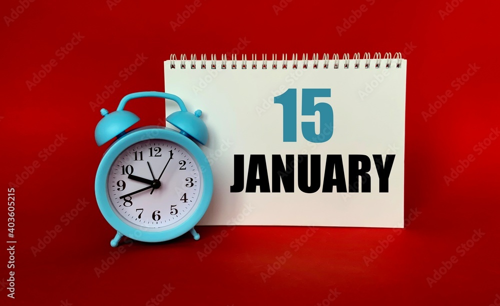 January 15 on a white Notepad .Next to it is a blue clock on a red background.Calendar for January . January 15 on a white Notepad .Next to it is a blue clock on a red background.Calendar for January .