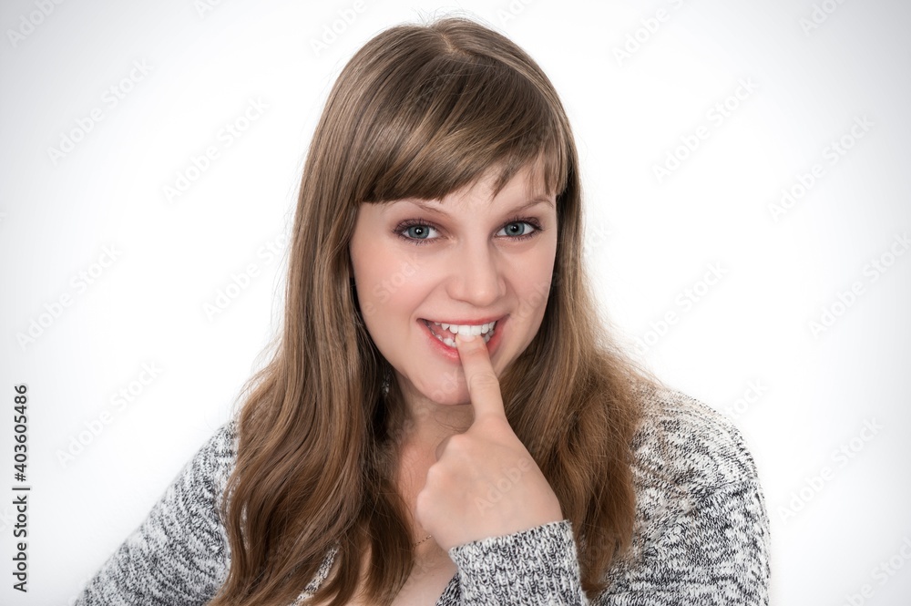 Woman showing tongue and is touching it with one finger