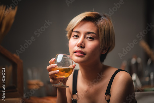 Attractive bartender girl holding in her hands fresh cocktail at the bar counter for celebration