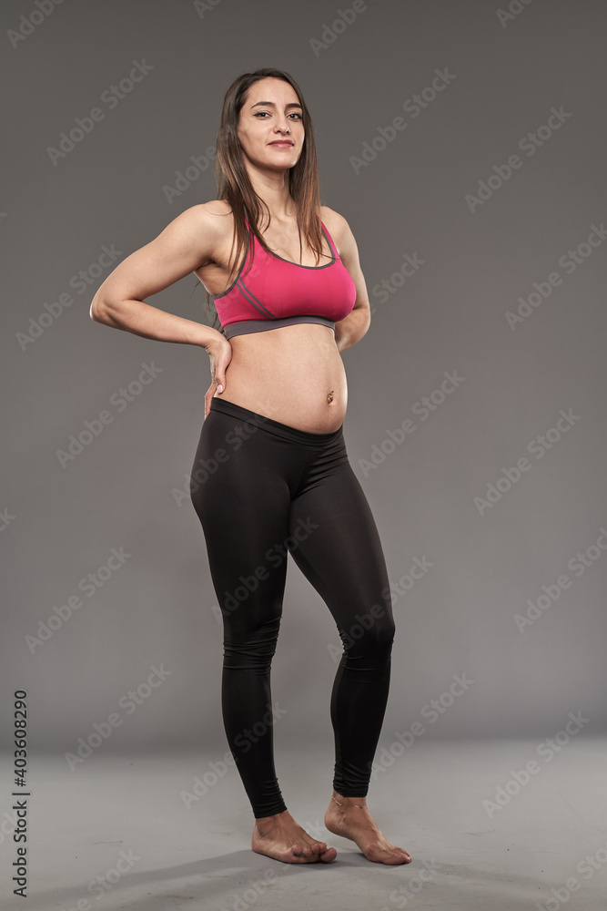 Active pregnant woman on gray