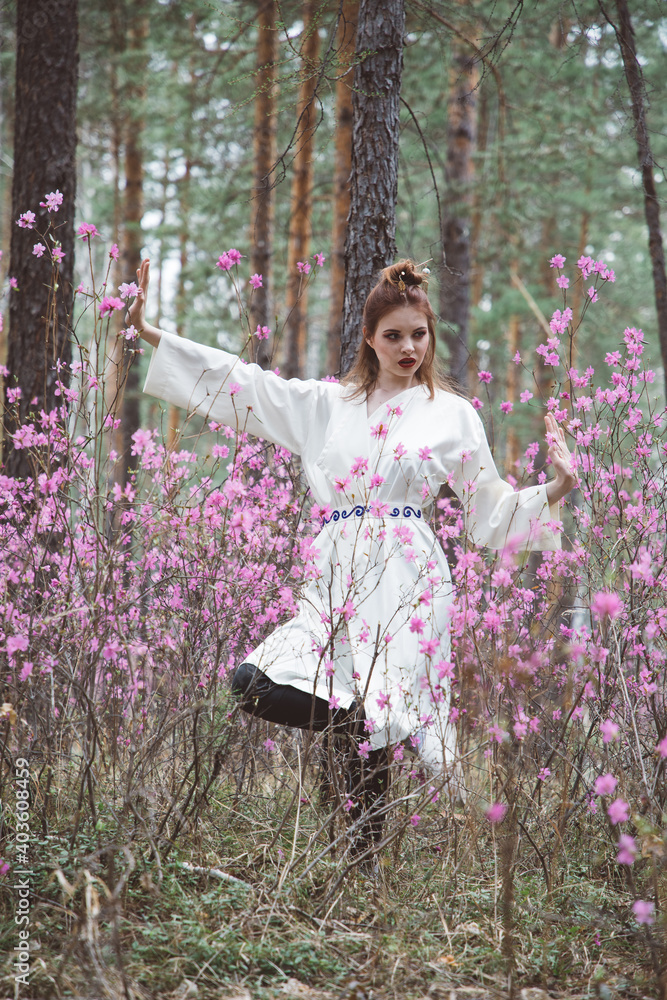 Japanese-style girl in a flowering forest among pink flowers in spring Japanese-style girl in a flowering forest among pink flowers in spring