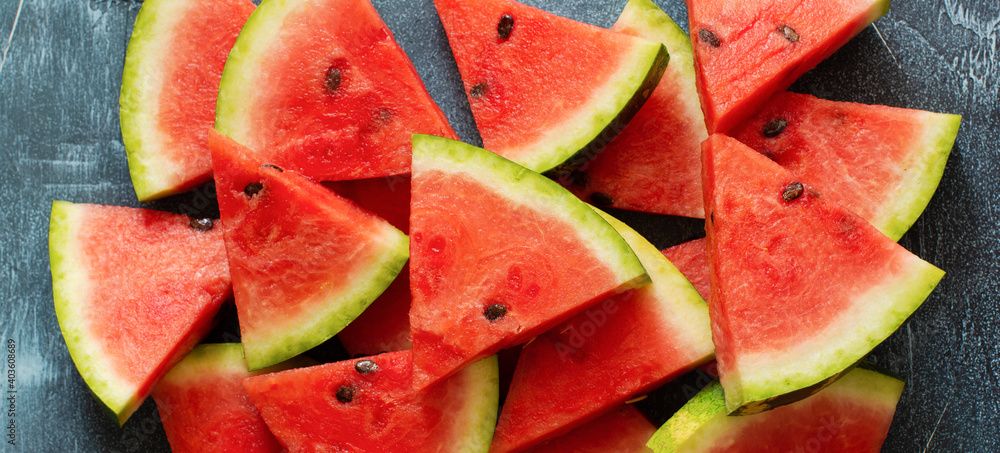 Slices of fresh watermelon with ice on a blue concrete background. Detox and vegetarian concept. Top view, copy space, banner Slices of fresh watermelon with ice on a blue concrete background. Detox and vegetarian concept. Top view, copy space, banner