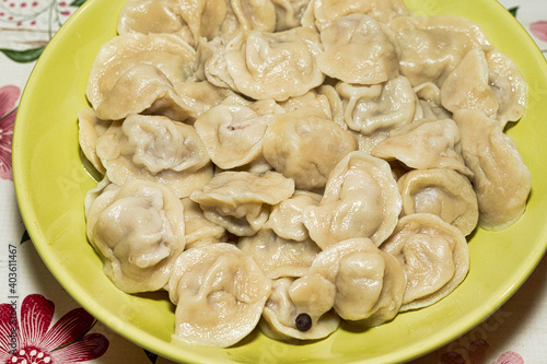 Cooked dumplings in a green plate on the dining table