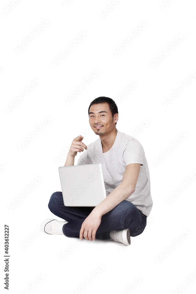 Cheerful businessman using a laptop computer on carpet Cheerful businessman using a laptop computer on carpet