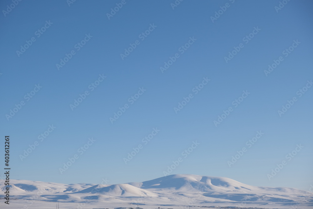 Snowy mountain with sunny and blue sky background