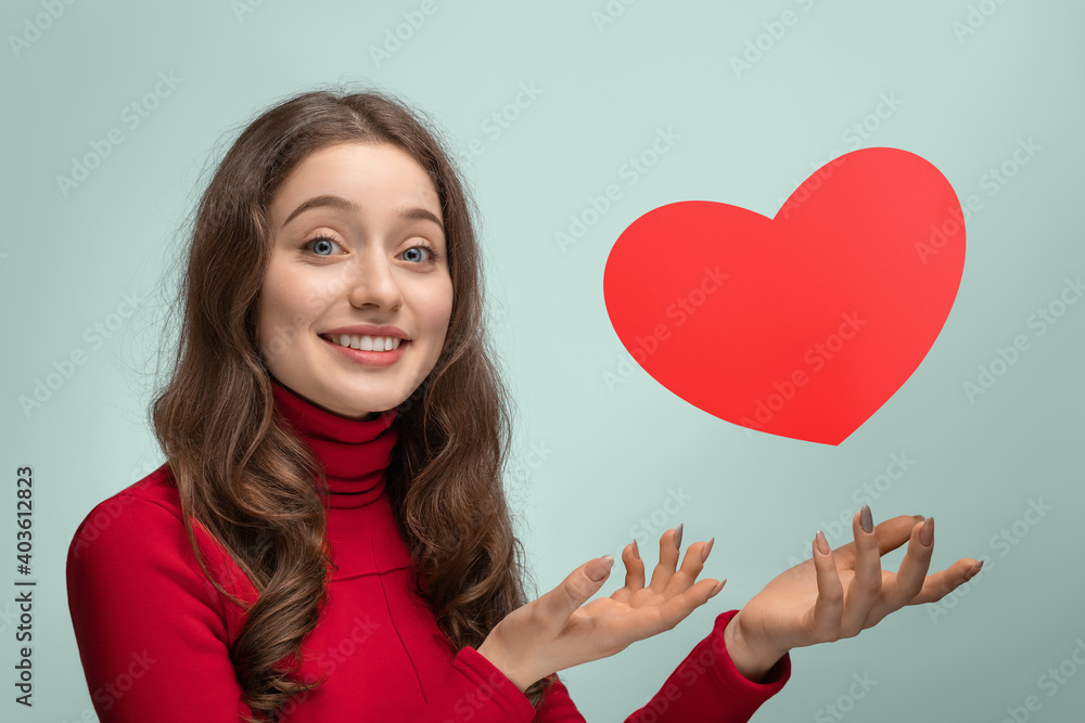 Girl with red cardboard heart, heart hanging in the air Girl with red cardboard heart, heart hanging in the air