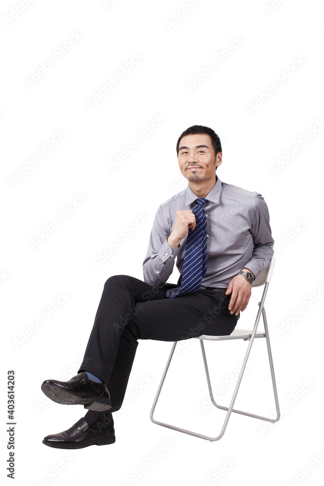 A cheerful young business man sitting posture A cheerful young business man sitting posture