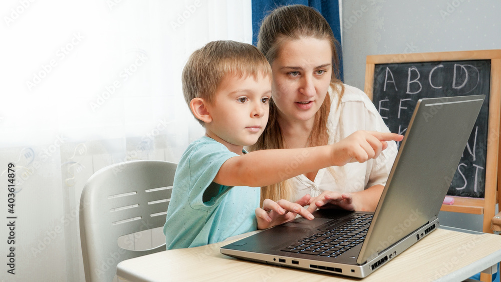 Little boy with young mother studying on laptop. Children using computer and gadget for education and learning. Little boy with young mother studying on laptop. Children using computer and gadget for education and learning.