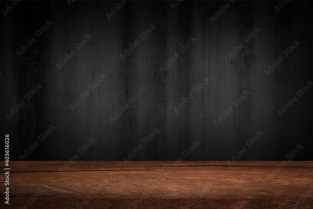 Free space on a wooden table for displaying products with a blurred black wall background. Free space on a wooden table for displaying products with a blurred black wall background.
