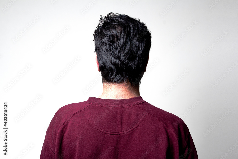 Backside of a man standing facing towards wall Backside of a man standing facing towards wall