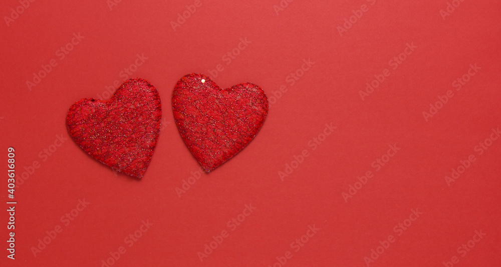 Two red hearts on a red background. Copy space. Festive background. Background for design.Top view