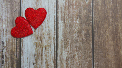 Two red hearts on a wooden background. Copy space. Festive background. Background for design.Top view