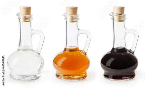 White, apple cider and balsamic vinegar in glass bottles isolated on white background photo