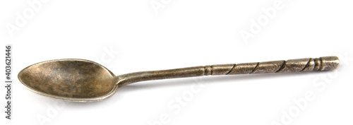 An antique silver spoon is isolated on a white background.