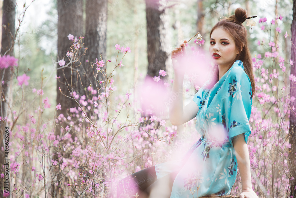 Japanese-style girl in a flowering forest among pink flowers in spring Japanese-style girl in a flowering forest among pink flowers in spring