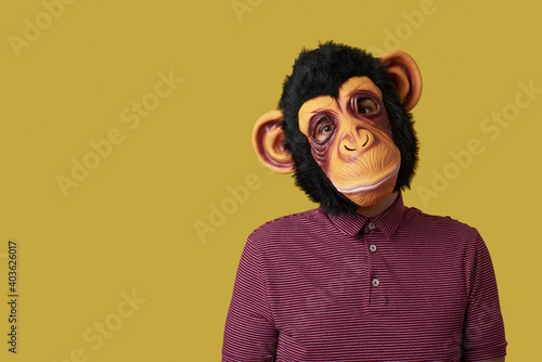 Bild auf Leinwand man wearing a monkey mask on a yellow