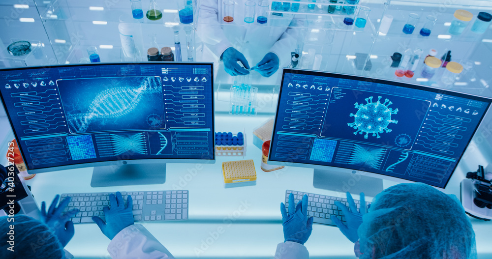 Two female scientists sitting in front of computer screens with ...