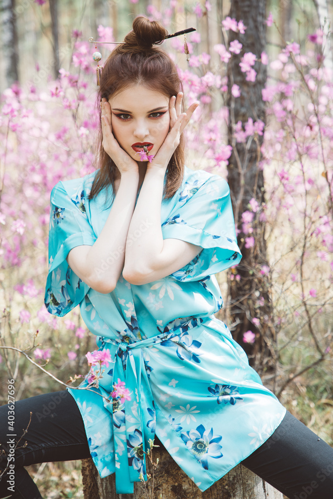 Japanese-style girl in a flowering forest among pink flowers in spring Japanese-style girl in a flowering forest among pink flowers in spring