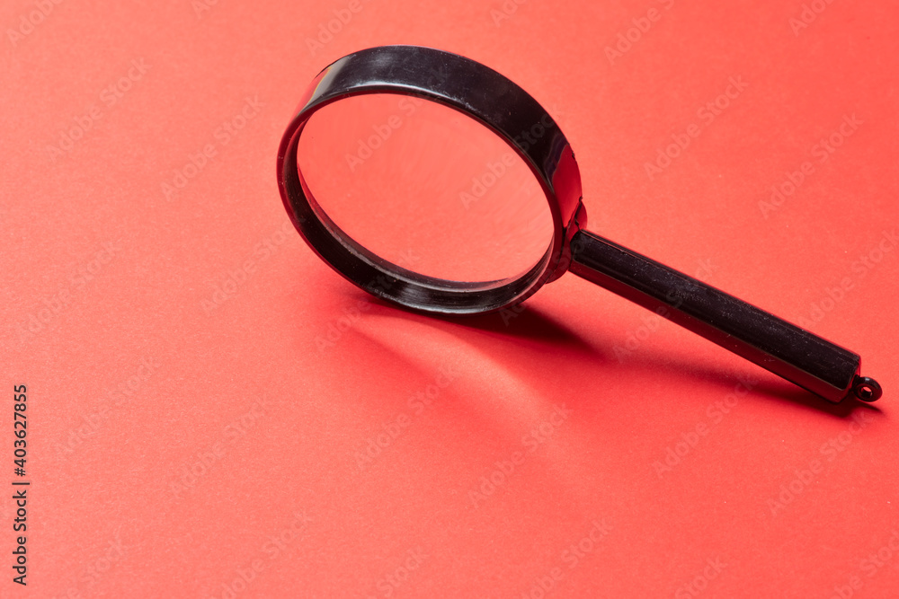 Black magnifier on a red background. Black magnifier on a red background.