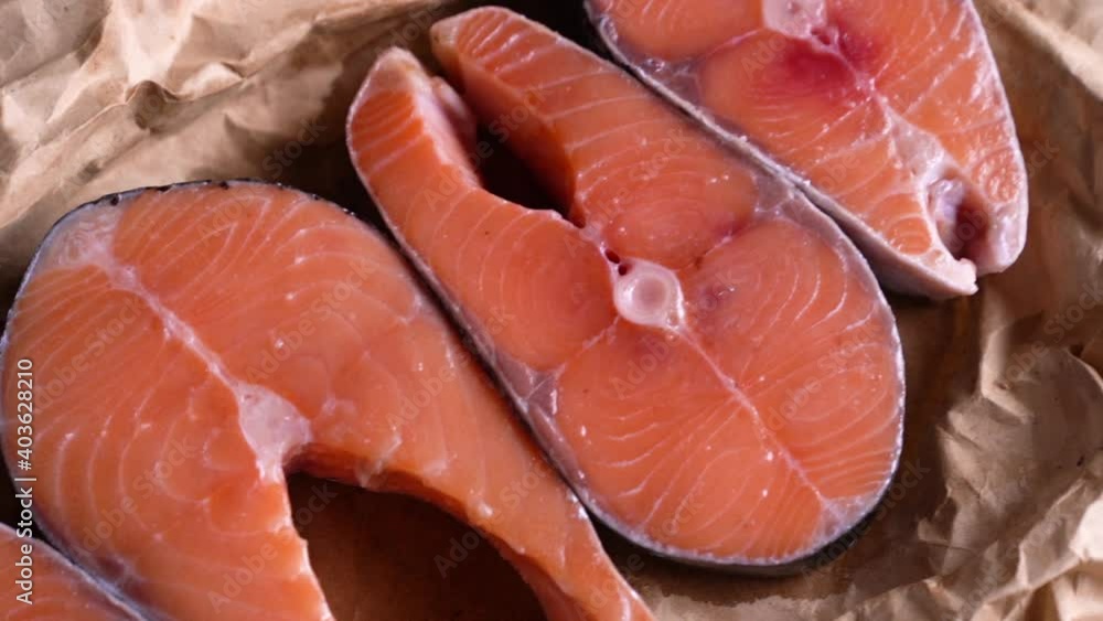 Fresh raw salmon fish steak with herbs and vegetables on wooden background Fresh raw salmon fish steak with herbs and vegetables on wooden background