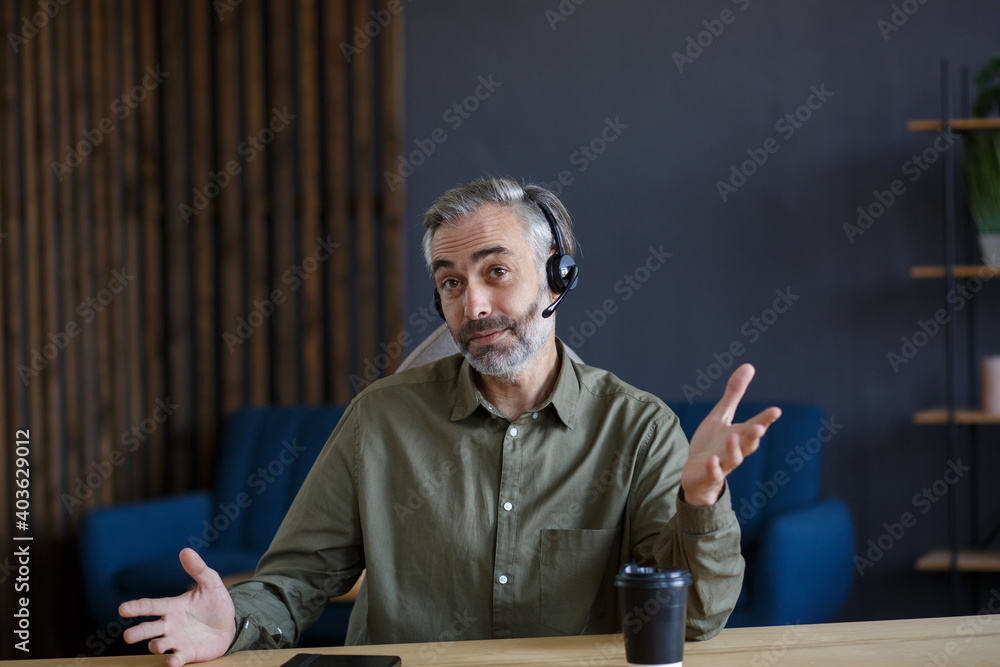 Portrait of grey-haired senior handsome man teaching online. Online education, remote working, home education. Online meeting, video call, video conference, courses online. Portrait of grey-haired senior handsome man teaching online. Online education, remote working, home education. Online meeting, video call, video conference, courses online.