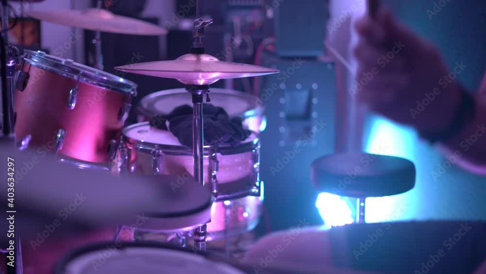 Skilled man musician plays contemporary drum set with wooden sticks on stage in semidark nightclub at concert close view slow motion. Skilled man musician plays contemporary drum set with wooden sticks on stage in semidark nightclub at concert close view slow motion.