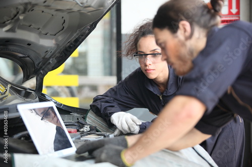 car mechanic use notebook computers to check engine and service maintenance of industrial to engine repair, for transport automobile automotive