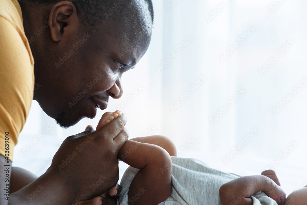 African father kissing feet newborn , newborn baby 15 days old, close up image, African family and newborn concept, father's day African father kissing feet newborn , newborn baby 15 days old, close up image, African family and newborn concept, father's day