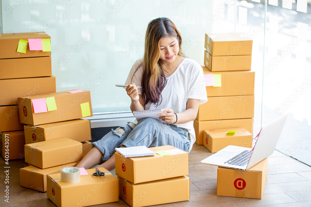 Portrait of Starting small businesses SME owners female entrepreneurs working, box and check online orders to prepare to pack the boxes, sell to customers, sme business ideas online. Portrait of Starting small businesses SME owners female entrepreneurs working, box and check online orders to prepare to pack the boxes, sell to customers, sme business ideas online.