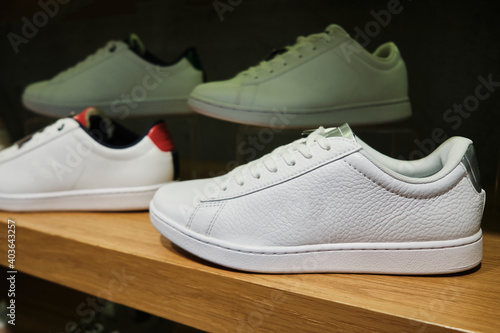 Blank white casual sneakers on the shelf of footwear store