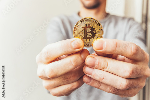 Man hand holding cryptocurrency golden bitcoin coin. Electronic virtual money for web banking and international network payment. Symbol of crypto virtual currency. Mining concept.