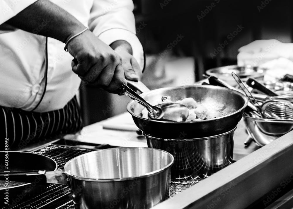 Chef cooking in a kitchen, chef at work, Black and White. Chef cooking in a kitchen, chef at work, Black and White.