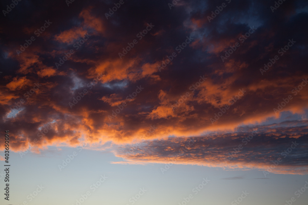 Sunset sky in the dusk with fiery clouds